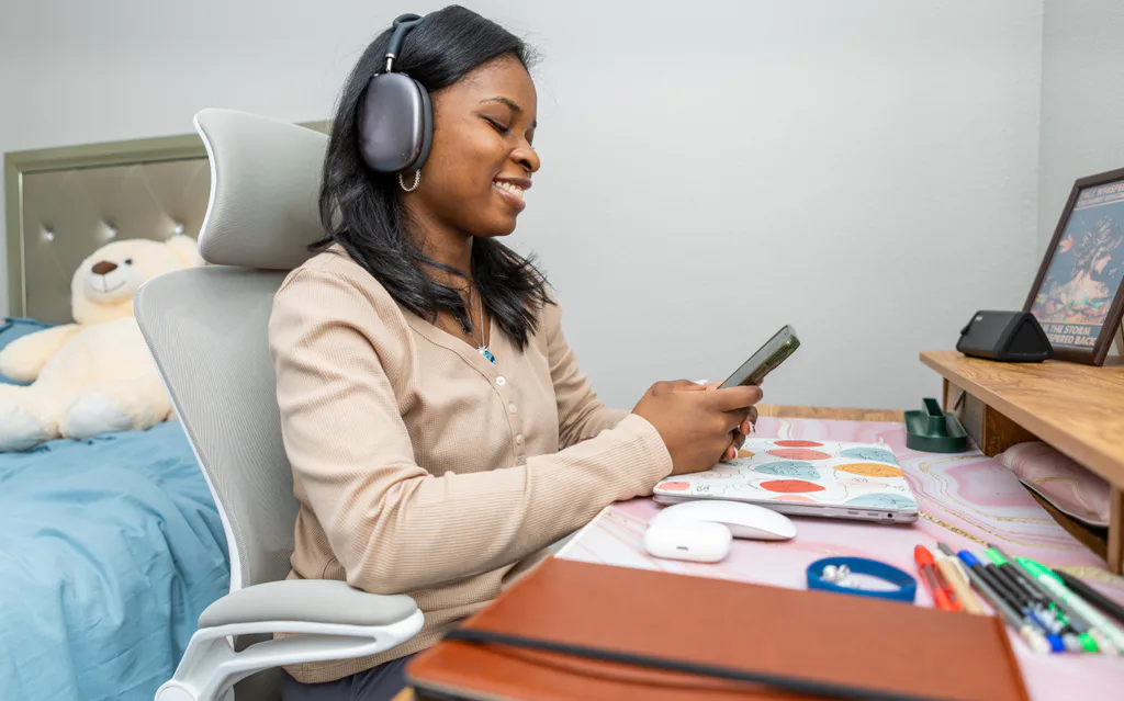 A woman using her phone while working at her desk